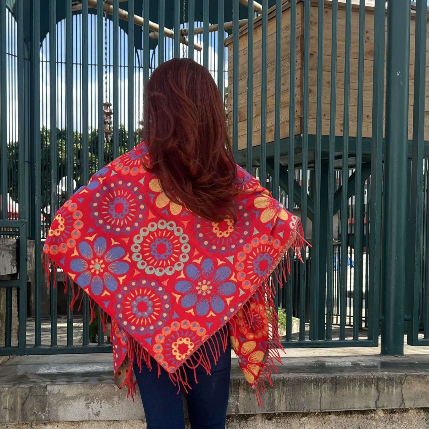 Mujer de Espalda Mostrando Parte Trasera de Pashmina Shawl Color Rojo y Estampado de Flores/Pololena & Co.
