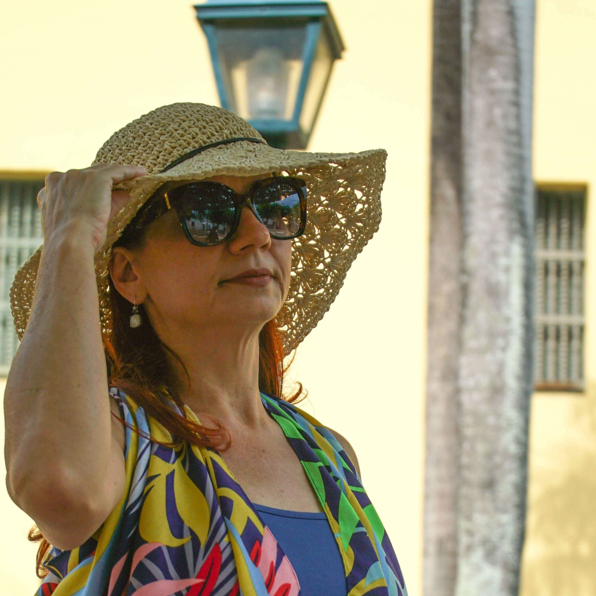 Mujer Protegiéndos del Sol en un Día de Paseo con un Elegante y Veraniego Sombrero Tejido/Pololena & Co.