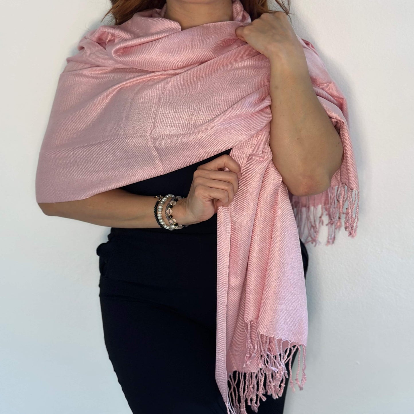 Mujer Cubriendo Elegantemente sus Hombros con una Estola Pashmina Color Rosa Claro/Pololena & Co.